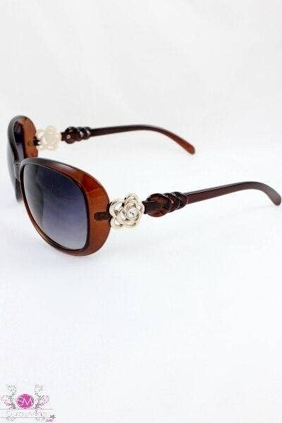 Maroon sunglasses with purple-tinted lenses, carved braided temples, and floral front emblem