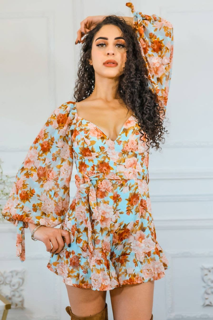 Floral V-neck ruffle romper with long puff sleeves and tiered skirt; front close-up pose