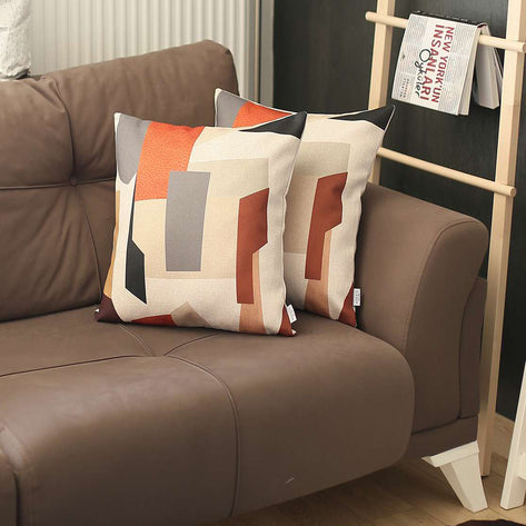 Printed throw pillow cover on couch, white with orange and gray rectangular blocks