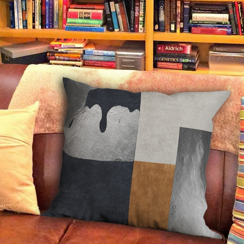 Decorative square pillow with dripping paint design in gray, white, and brown blocks