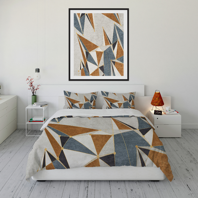 Geometric comforter set on bed with brown, blue, and white abstract triangle print