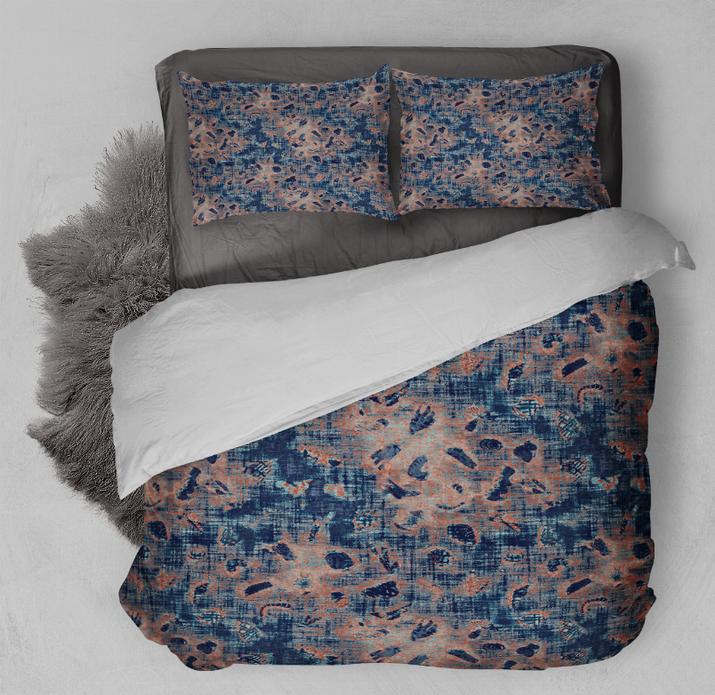 Blue and orange abstract comforter set with two matching shams on bed