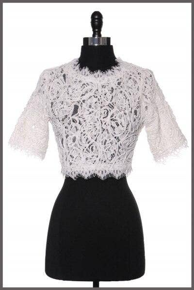 White embroidered lace cropped top with vine-like pattern and short fringed sleeves