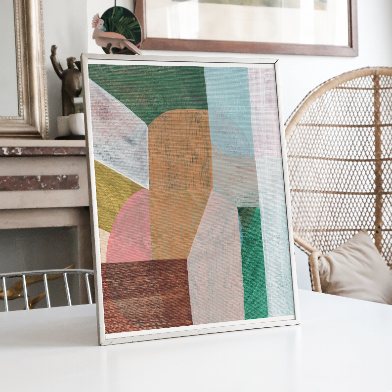 Framed abstract wall art leaning with teal, orange, and pink geometric blocks