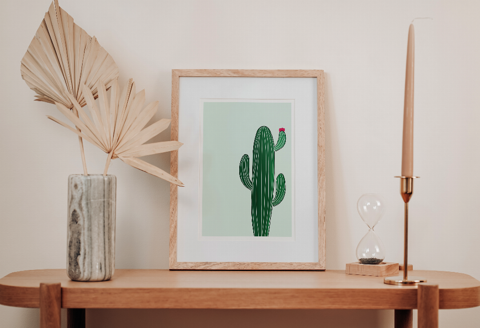 Framed cactus wall art with green striped cactus and pink flower on mint square