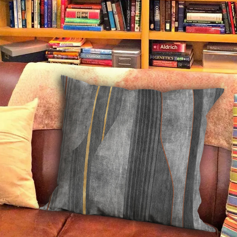Large square throw pillow with dark gray panels, vertical gold stripes, red edge piping.