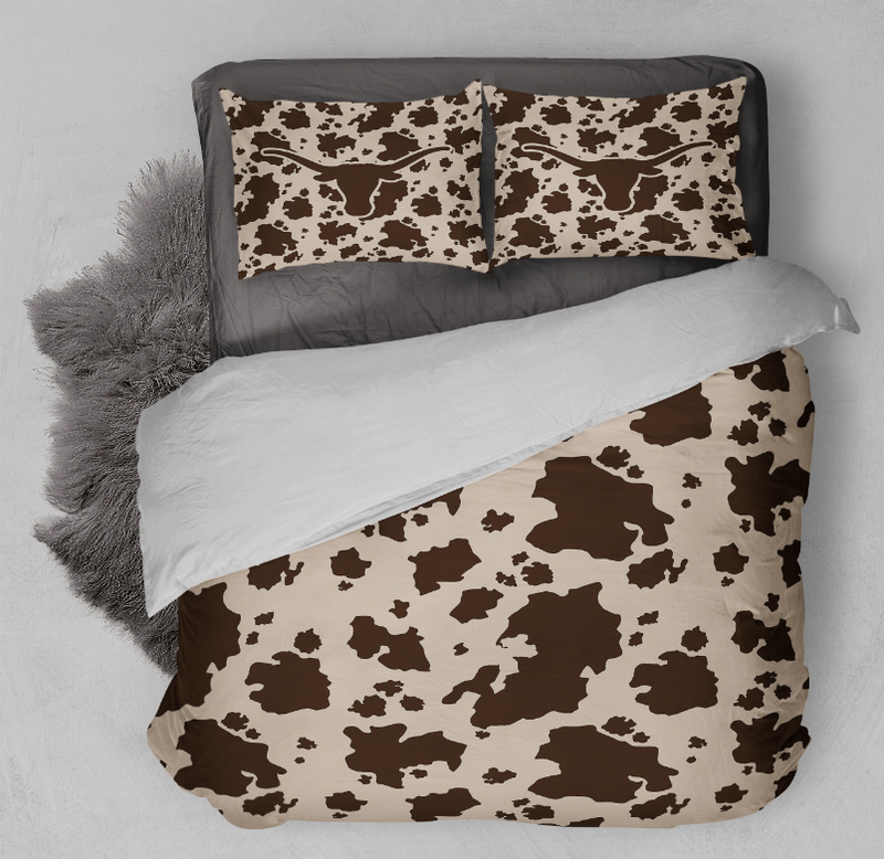 Cow-print comforter and two matching pillow shams on bed