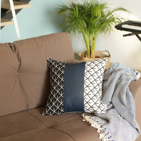 Square geometric throw pillow with navy center panel and black/white lattice pattern