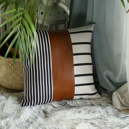 Striped throw pillow cover with brown faux leather middle panel and vertical black-white stripes