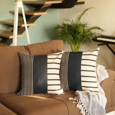 Pair of boho striped throw pillow covers in black, white, and blue vertical/horizontal panels