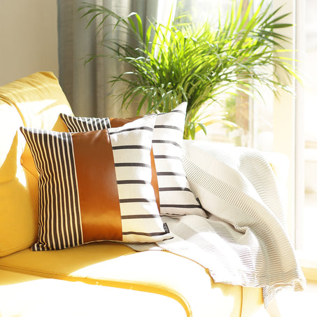 Two pillow covers: black-and-white striped design with terracotta solid panel
