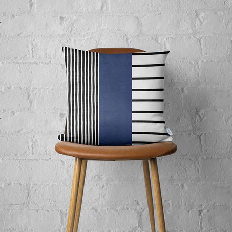 Striped throw pillow cover on chair seat with navy faux leather panel and black-and-white stripes