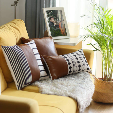 Brown faux leather pillow with striped and diamond patterned covers on shag rug