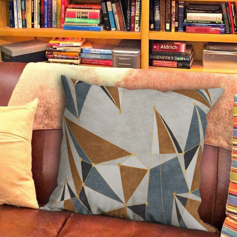 Geometric throw pillow in gray with blue, tan, and white abstract line triangles