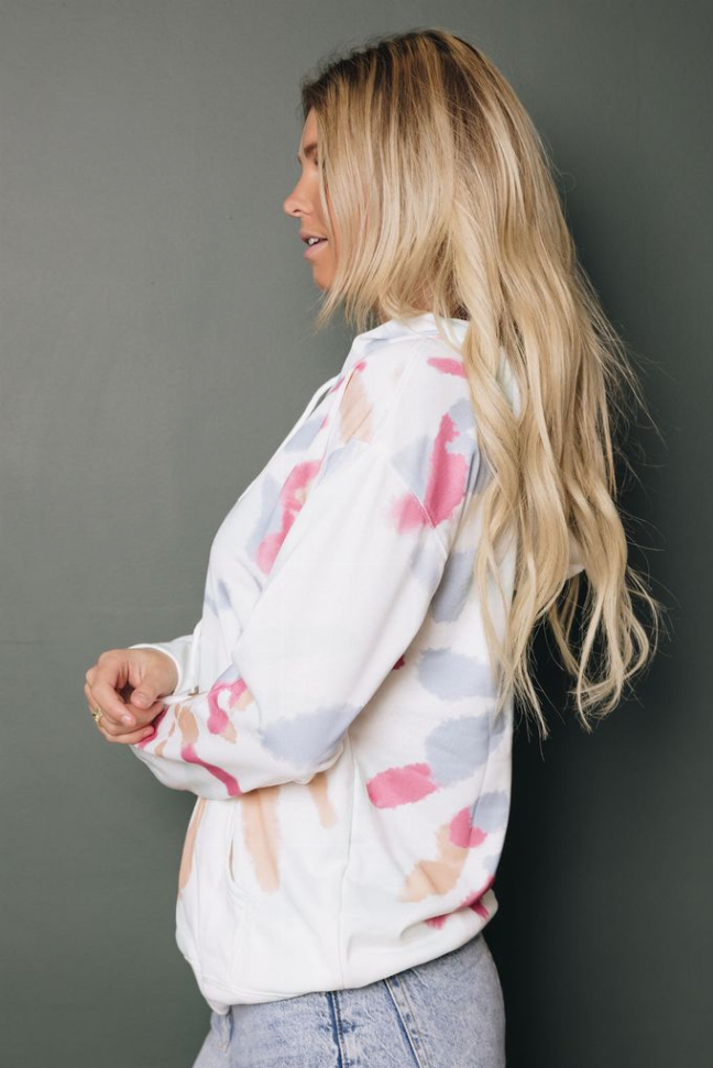 White tie-dye hoodie with pink and peach blotches, long sleeves and hood