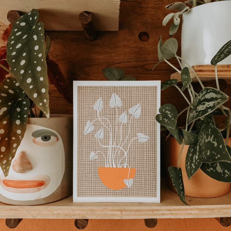 Framed potted plant artwork with gray leaf outlines and orange pot on a grid