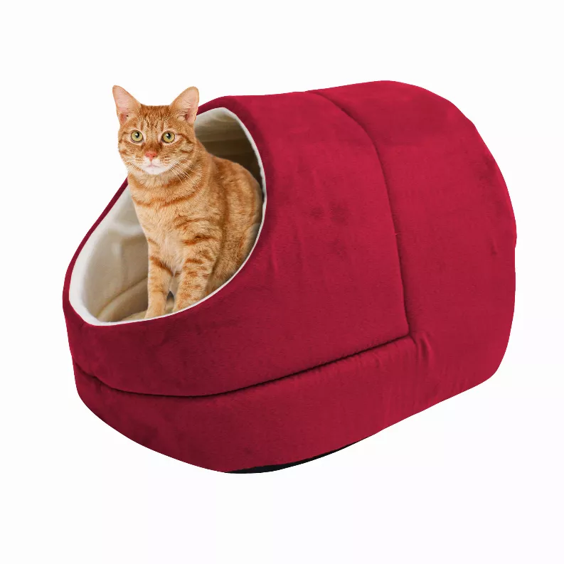 Red cat cave bed with cream-trimmed circular entrance and orange tabby cat inside