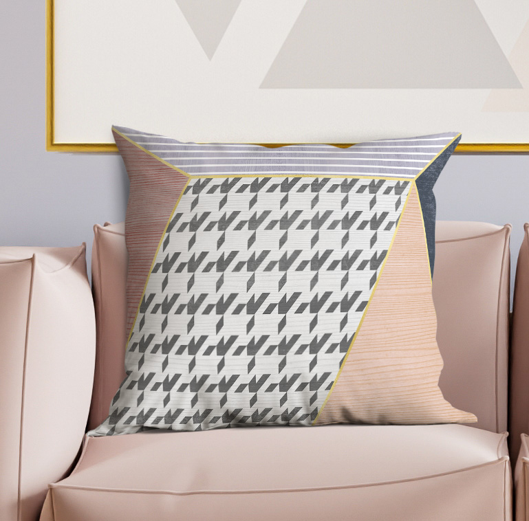 Geometric throw pillow on sofa with gray-and-white zigzag print and tan side panel