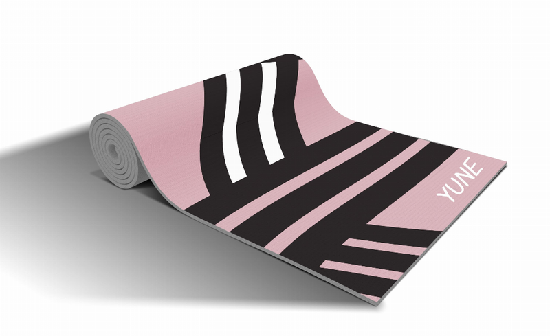 Yoga mat rolled up with pink/black stripe pattern and YUNE text on right edge