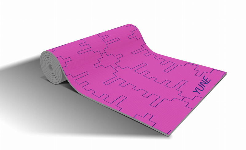 Rolled magenta yoga mat with repeating geometric pattern, showing gray grip base
