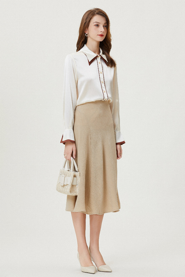 Cream silk blouse with brown-trim collar and long sleeves, tucked over midi skirt