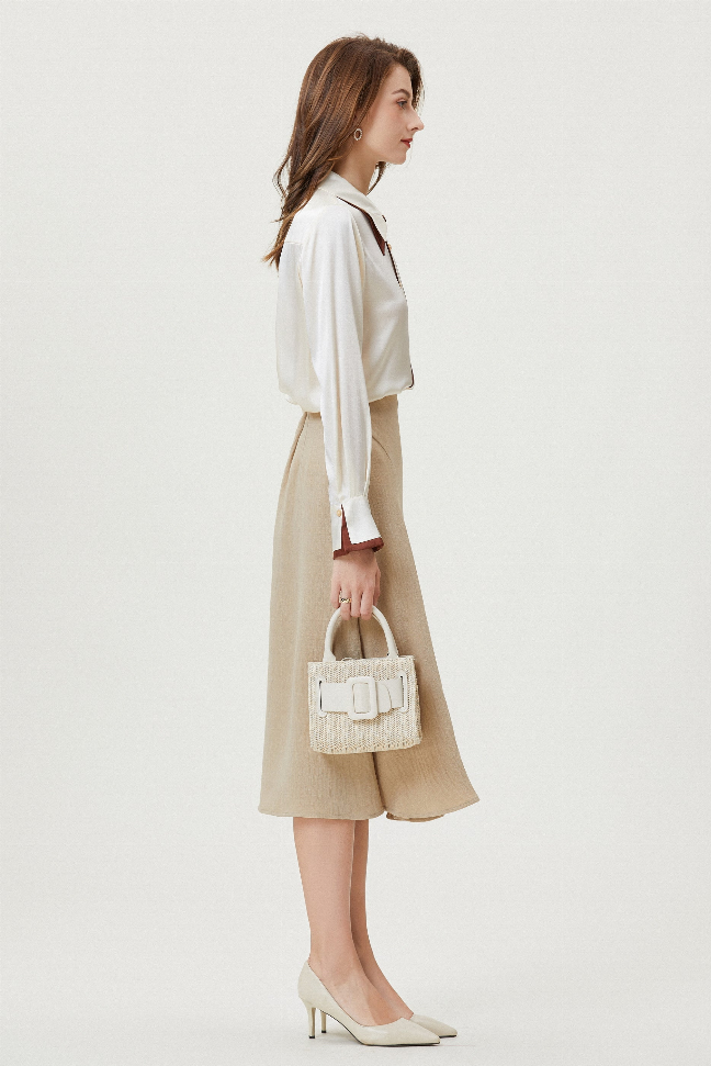Cream silk button-up shirt with brown-trim collar, worn with tan midi skirt