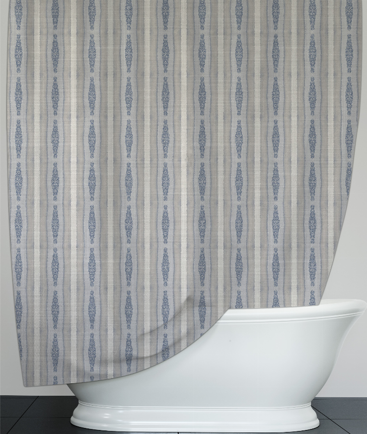 Shower curtain with blue medallion stripe design, draped beside white bathtub