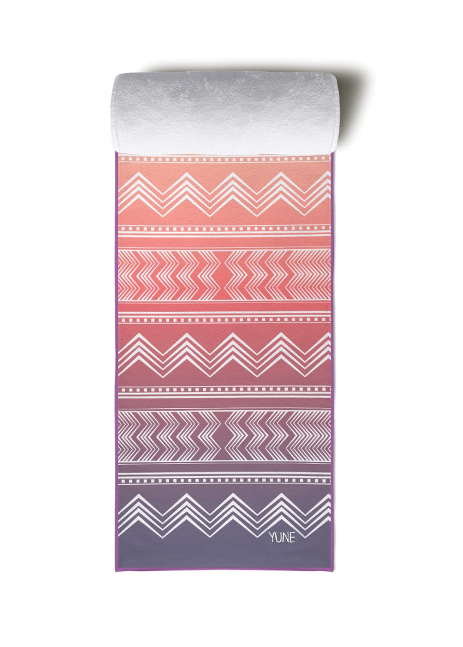 Yoga towel with zigzag pattern, folded, coral, pink, and purple bands with YUNE