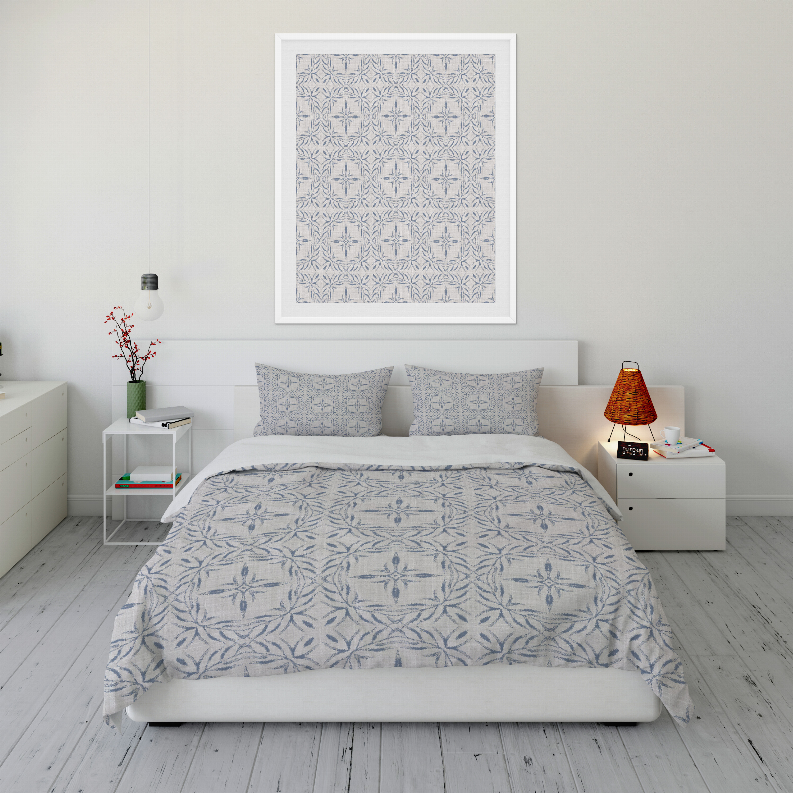 Blue and white patterned comforter set with two pillow shams, neatly spread.