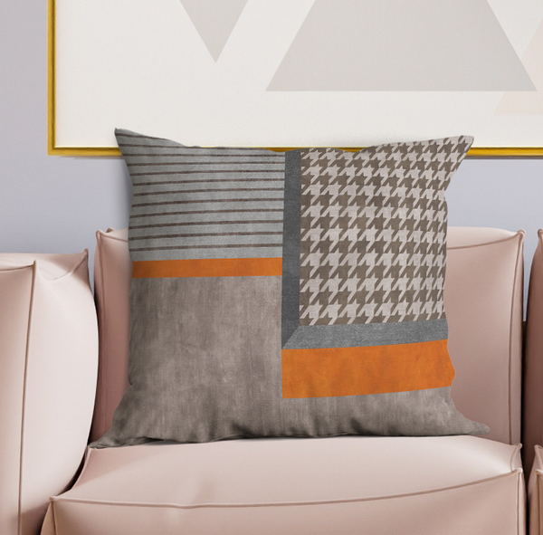 Geometric throw pillow with gray houndstooth, stripes, and orange band accents