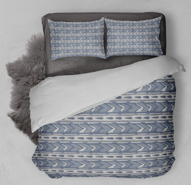 Blue and gray geometric comforter set with two pillow shams, layered on bed
