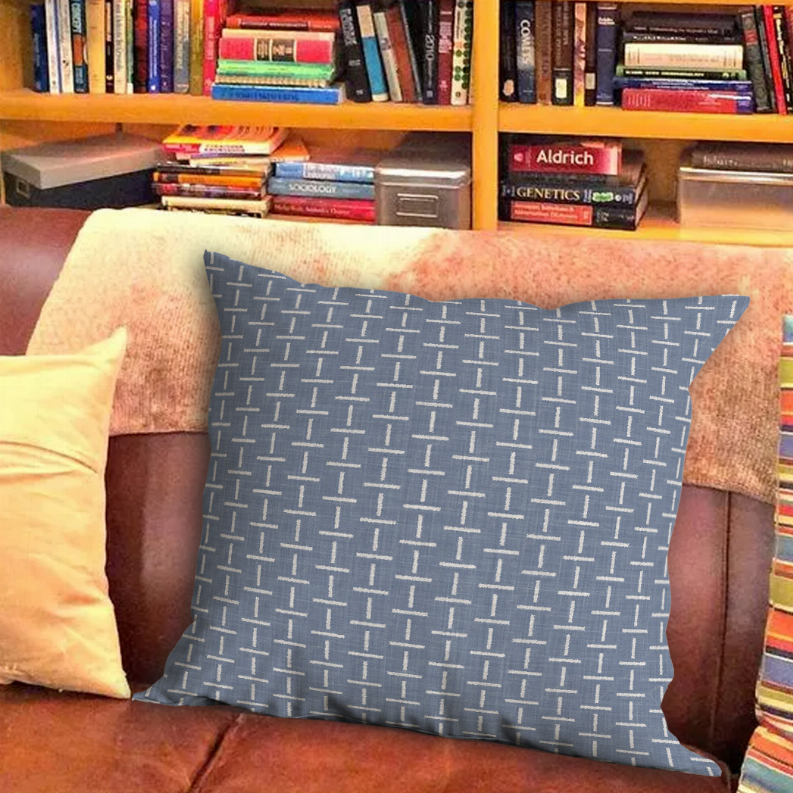 Square throw pillow in dark blue with repeating white geometric line pattern
