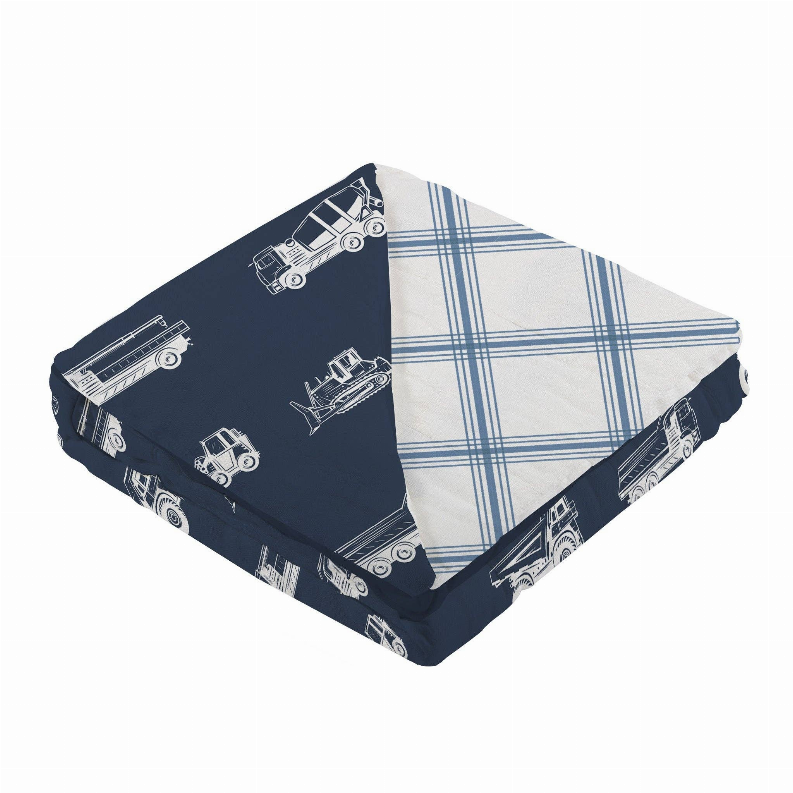 Folded cotton blanket with dark blue tractor pattern and cream-and-blue plaid reverse