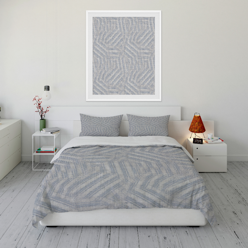 Light blue geometric comforter with two matching pillow shams on bed