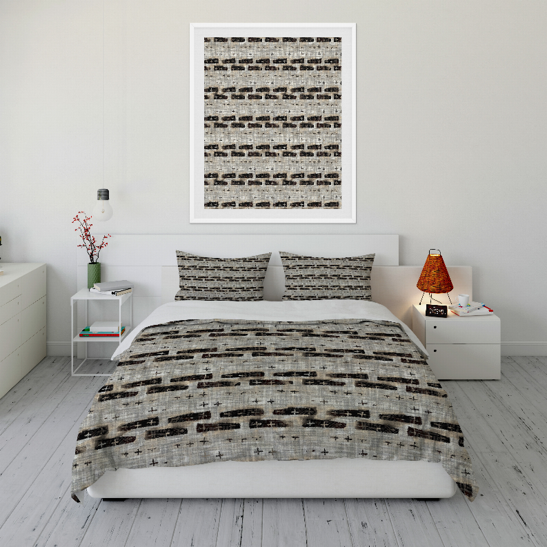 Comforter set with gray and black abstract pattern, bed made with two pillows and matching throw