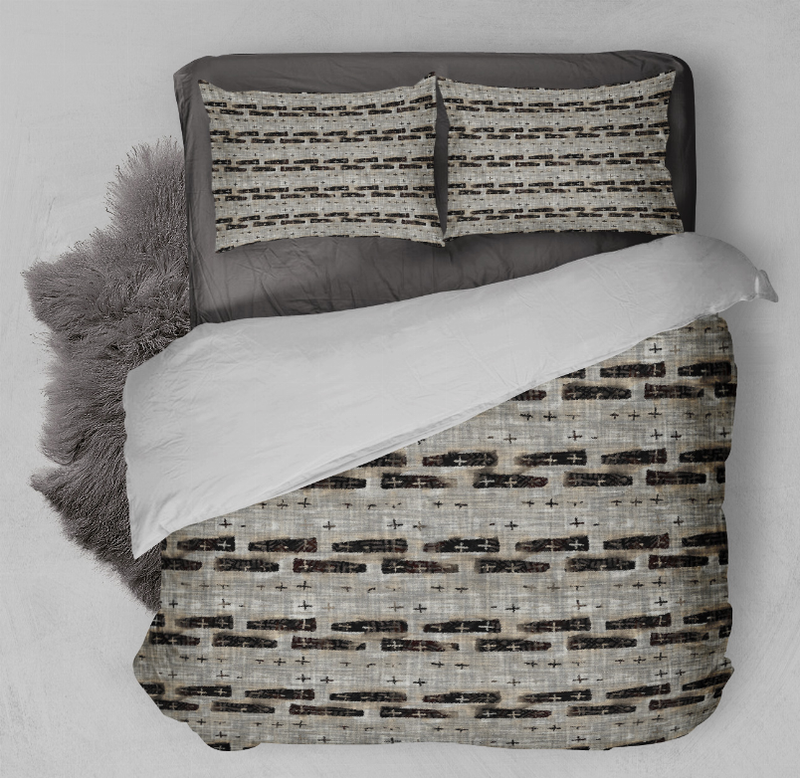 Gray and black abstract comforter set with two matching pillows on a bed