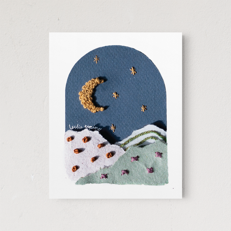 Framed moon and star wall art close-up, gold crescent, stars, and green hills