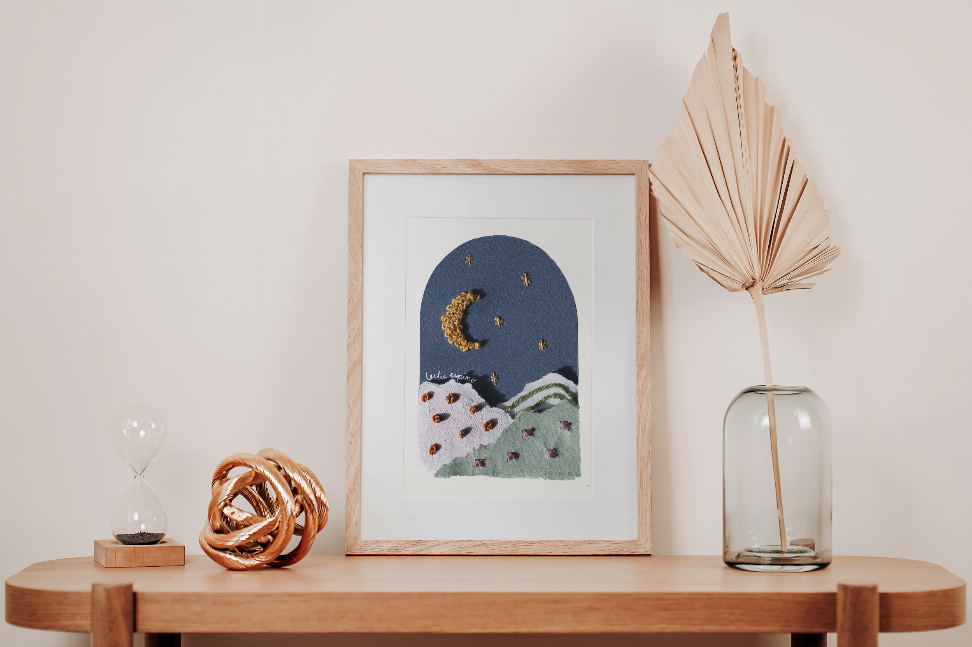 Framed moon and star wall art on round shelf, textured blue night scene with crescent moon