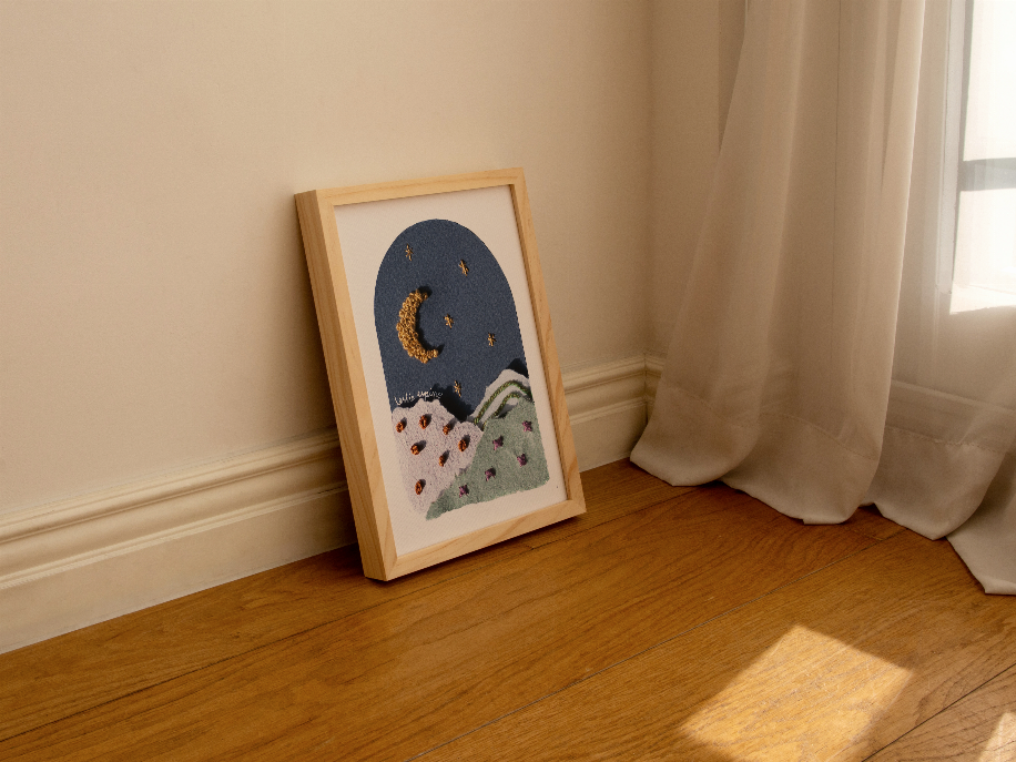 Framed moon and star wall art on floor, textured blue sky with crescent moon