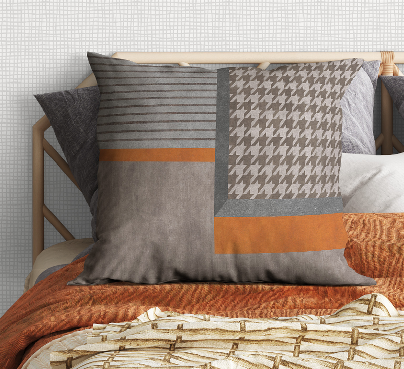 Gray throw pillow featuring houndstooth panel, horizontal stripes, and orange band.