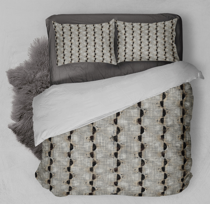 Comforter set close-up: off-white duvet with black geometric dots and two patterned pillow shams