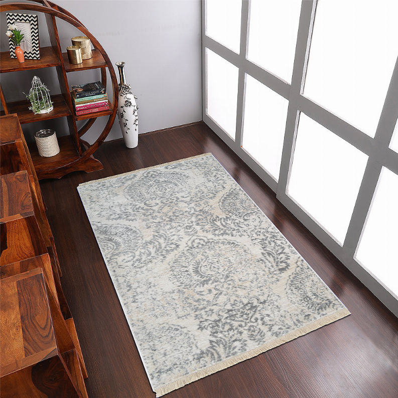 Cream and blue-gray area rug with damask motifs, distressed look, and fringe border