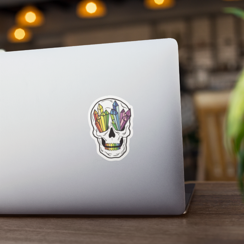 Rainbow crystal skull sticker on white laptop, centered colorful gem-crystal skull