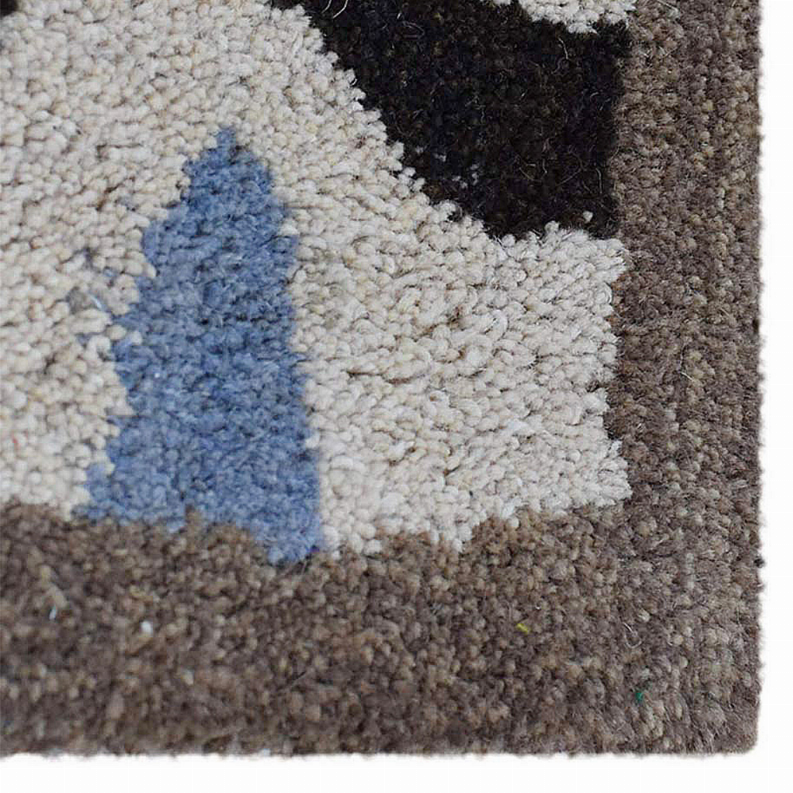 Cream shag area rug with blue silhouette shape and dark charcoal border