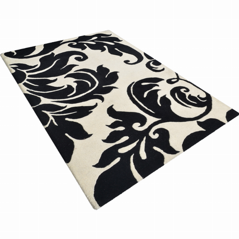 Black and ivory floral area rug with ornate swirl pattern, angled on white