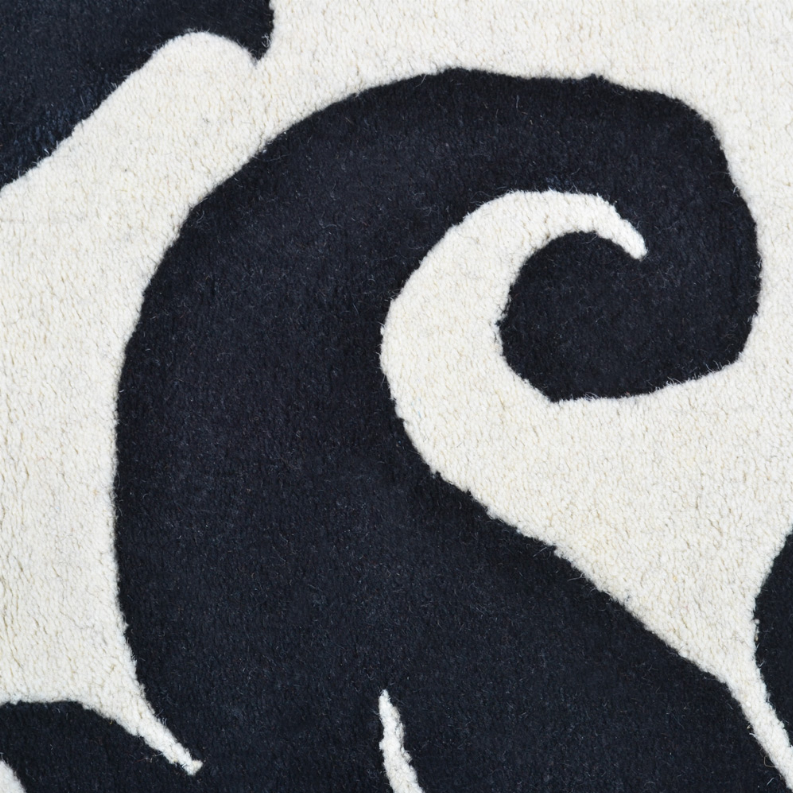 Black and ivory floral rug close-up showing bold curved swirl design