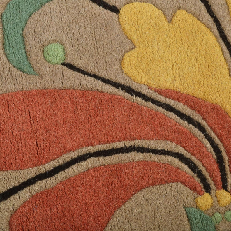 Hand-tufted wool area rug with colorful floral accents, curved border and black trim