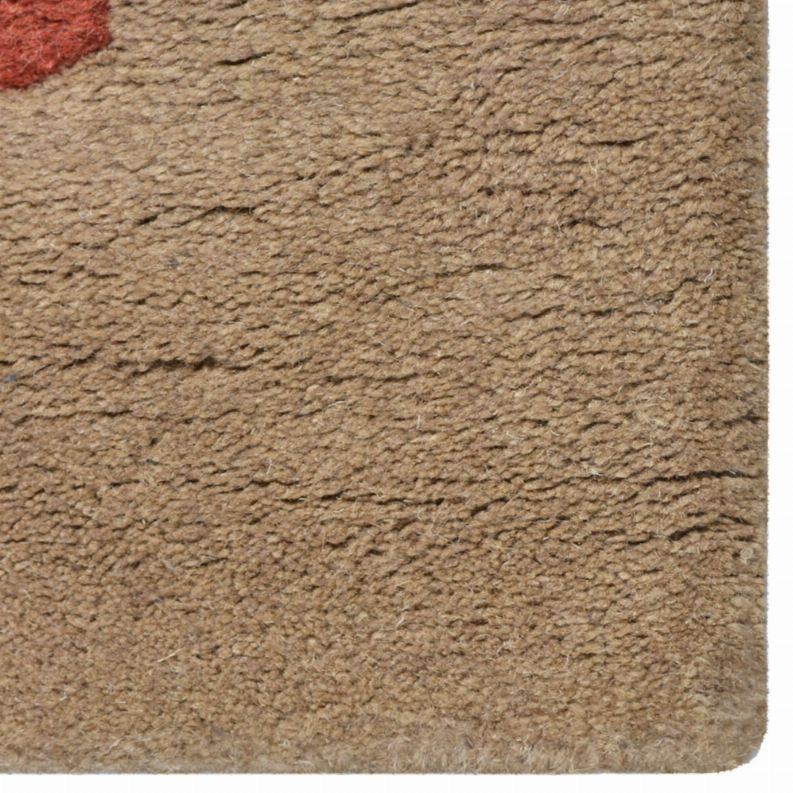 Beige rug corner close-up showing dense hand-tufted wool texture and trimmed edge