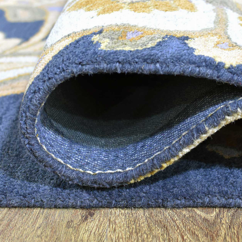 Hand-tufted wool rug rolled edge detail with navy fabric binding