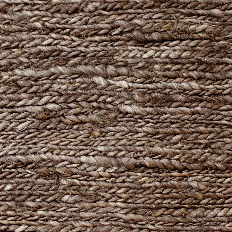 Brown jute area rug close-up, braided weave pattern